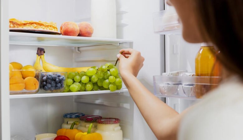 Полки холодильника, на которых аккуратно размещены разнообразные продукты питания: овощи и фрукты в специальных ящиках, молочные продукты в одной зоне, мясо и рыба в другой.